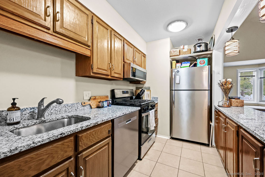 9 Talcott Ridge Road, Unit A4 Farmington, CT 06032 - Photo 9 of 28 a kitchen with stainless steel appliances granite countertop a refrigerator a sink and a stove