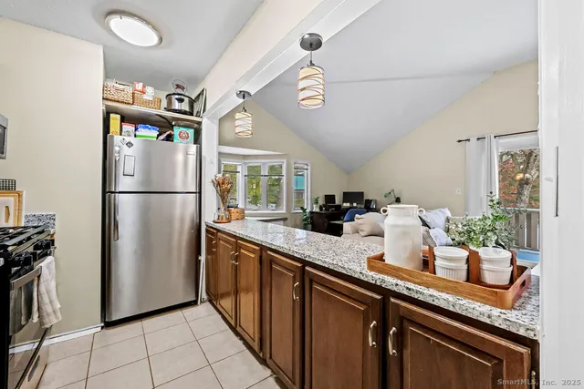 a kitchen with stainless steel appliances granite countertop a refrigerator a sink and dishwasher