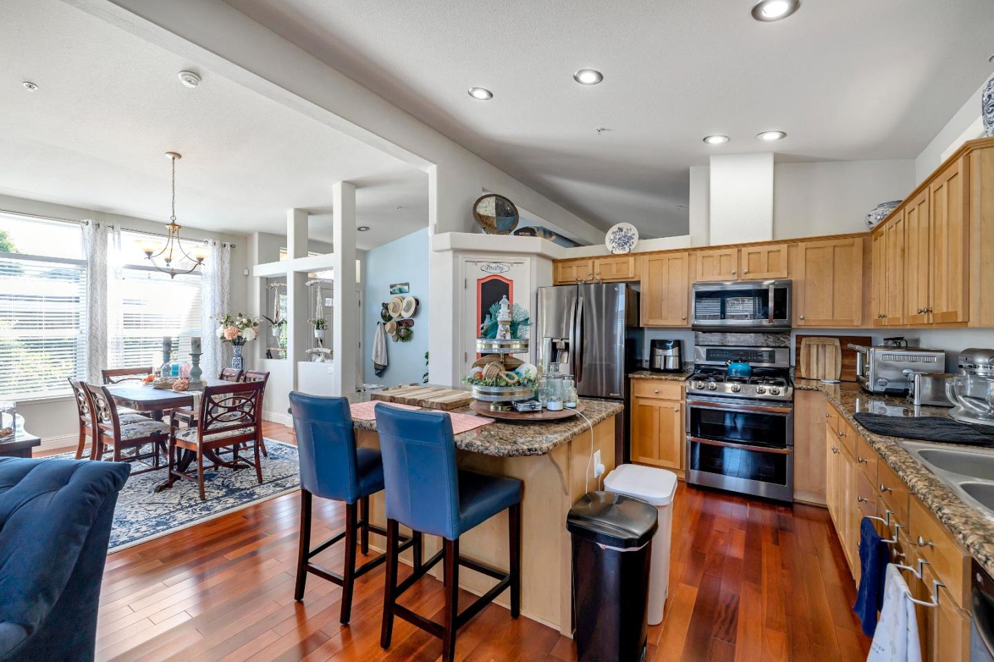 552 Filbert Street Half Moon Bay, CA 94019 - Photo 16 of 34 a kitchen with stainless steel appliances kitchen island granite countertop a stove top oven a sink a dining table and chairs with wooden floor