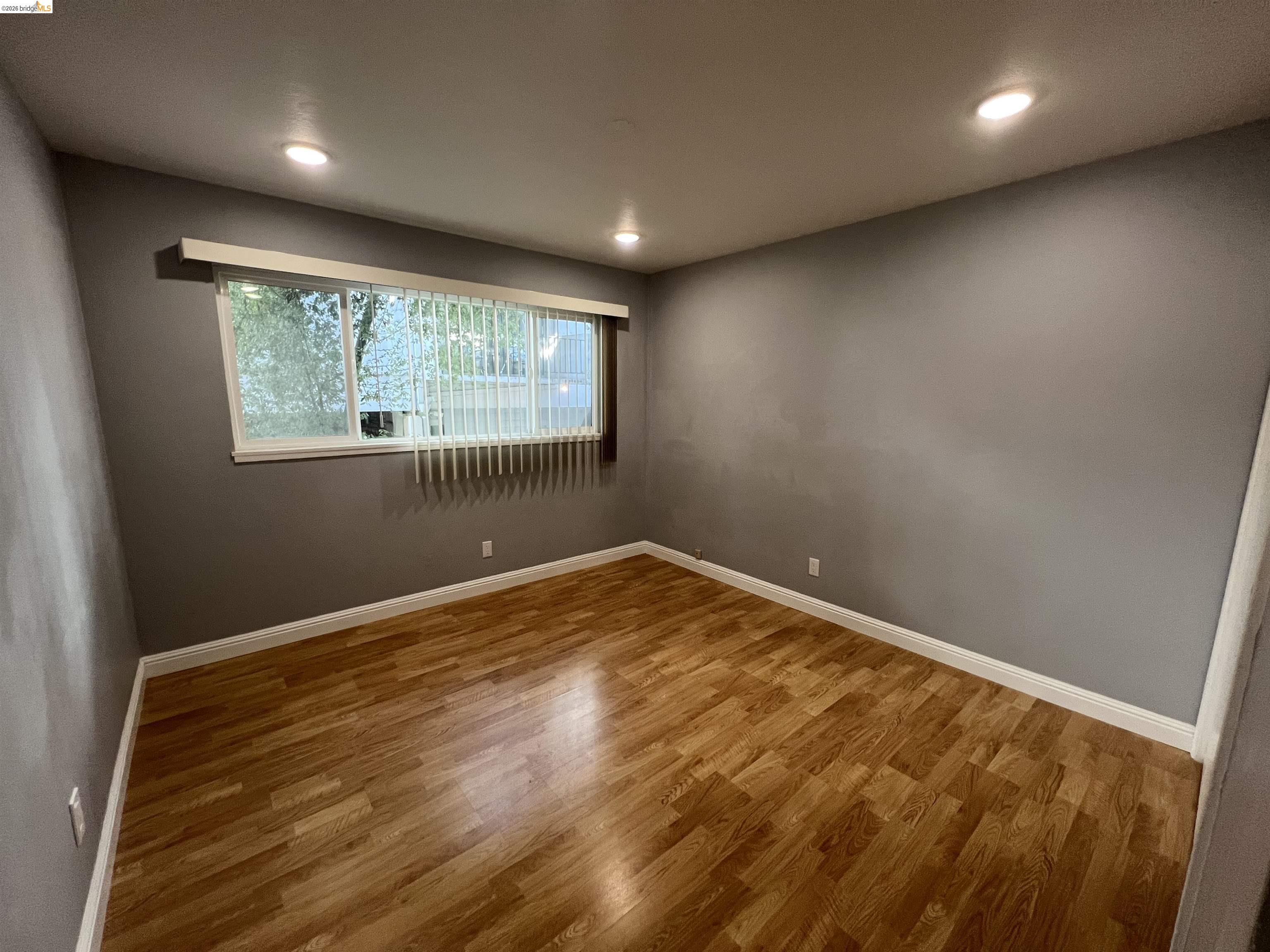 2636 Warring Street, Unit 102 Berkeley, CA 94704 - Photo 2 of 6 an empty room with wooden floor and windows