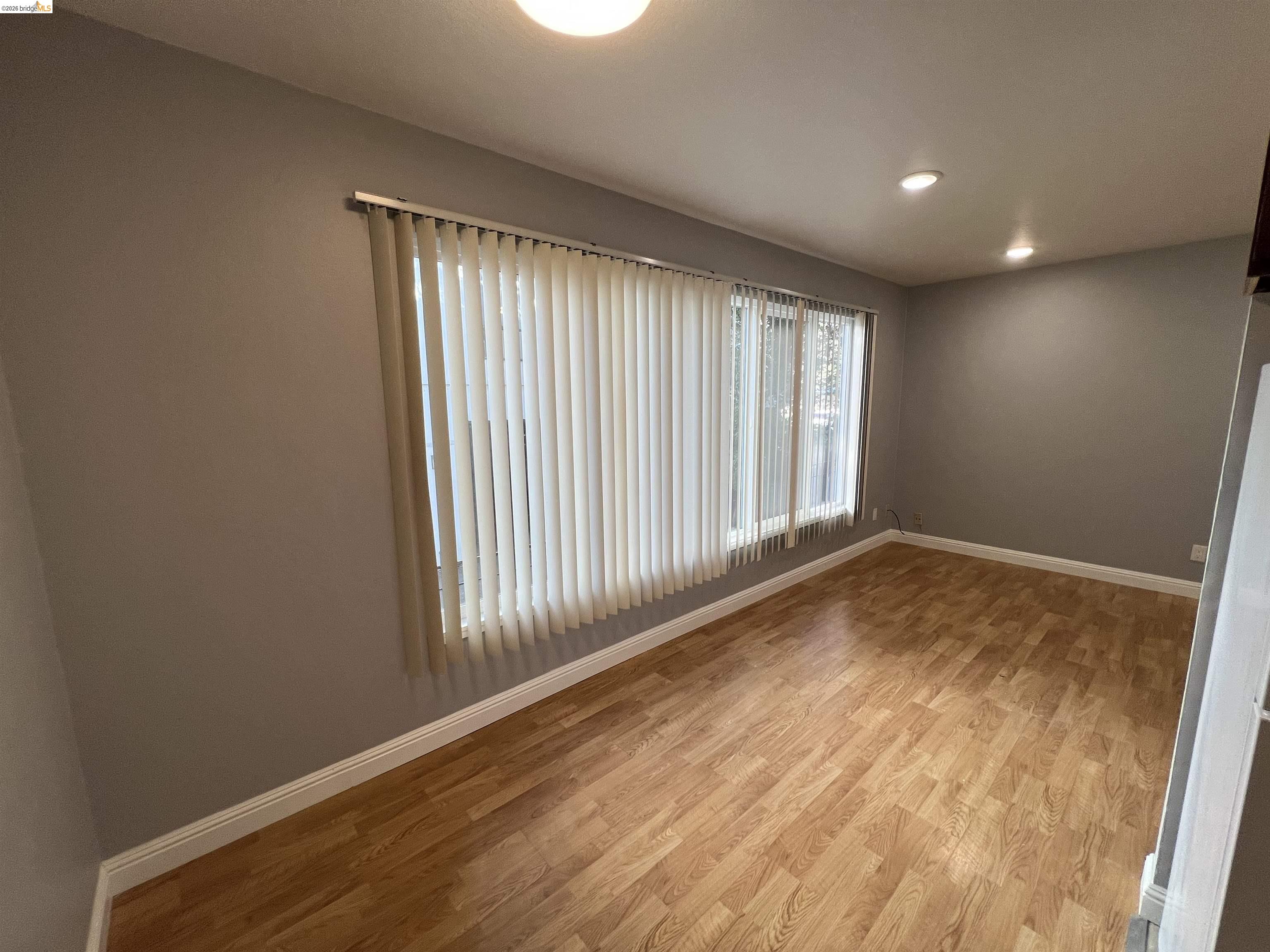 2636 Warring Street, Unit 102 Berkeley, CA 94704 - Photo 4 of 6 an empty room with wooden floor and windows