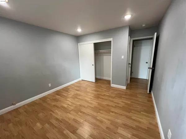 an empty room with wooden floor and entrance