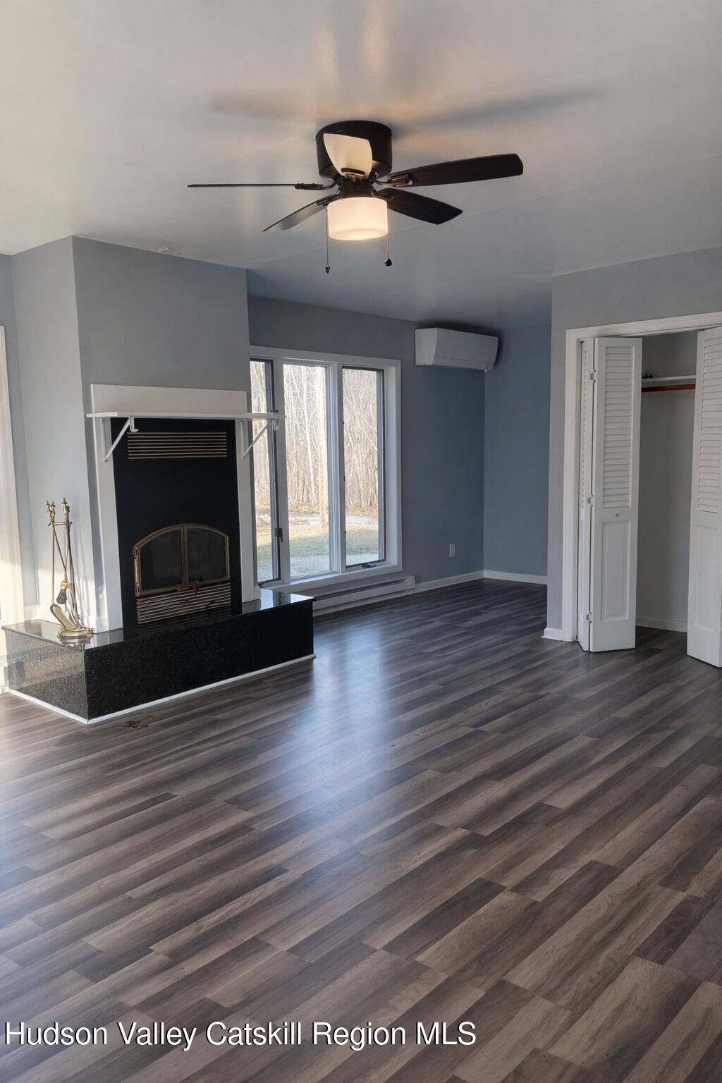 51 Hay Press Road Craryville, NY 12521 - Photo 11 of 27 an empty room with wooden floor fireplace and windows
