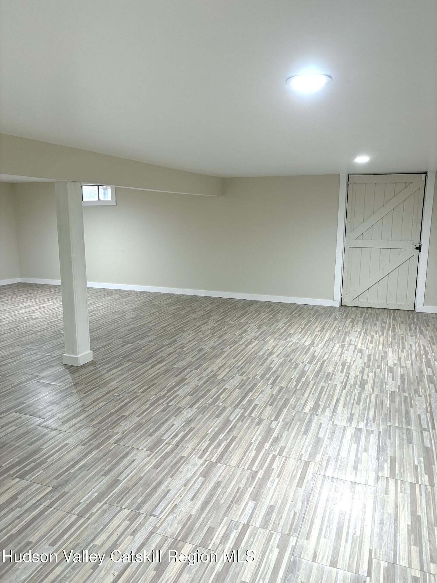 51 Hay Press Road Craryville, NY 12521 - Photo 23 of 27 an empty room with wooden floor and windows