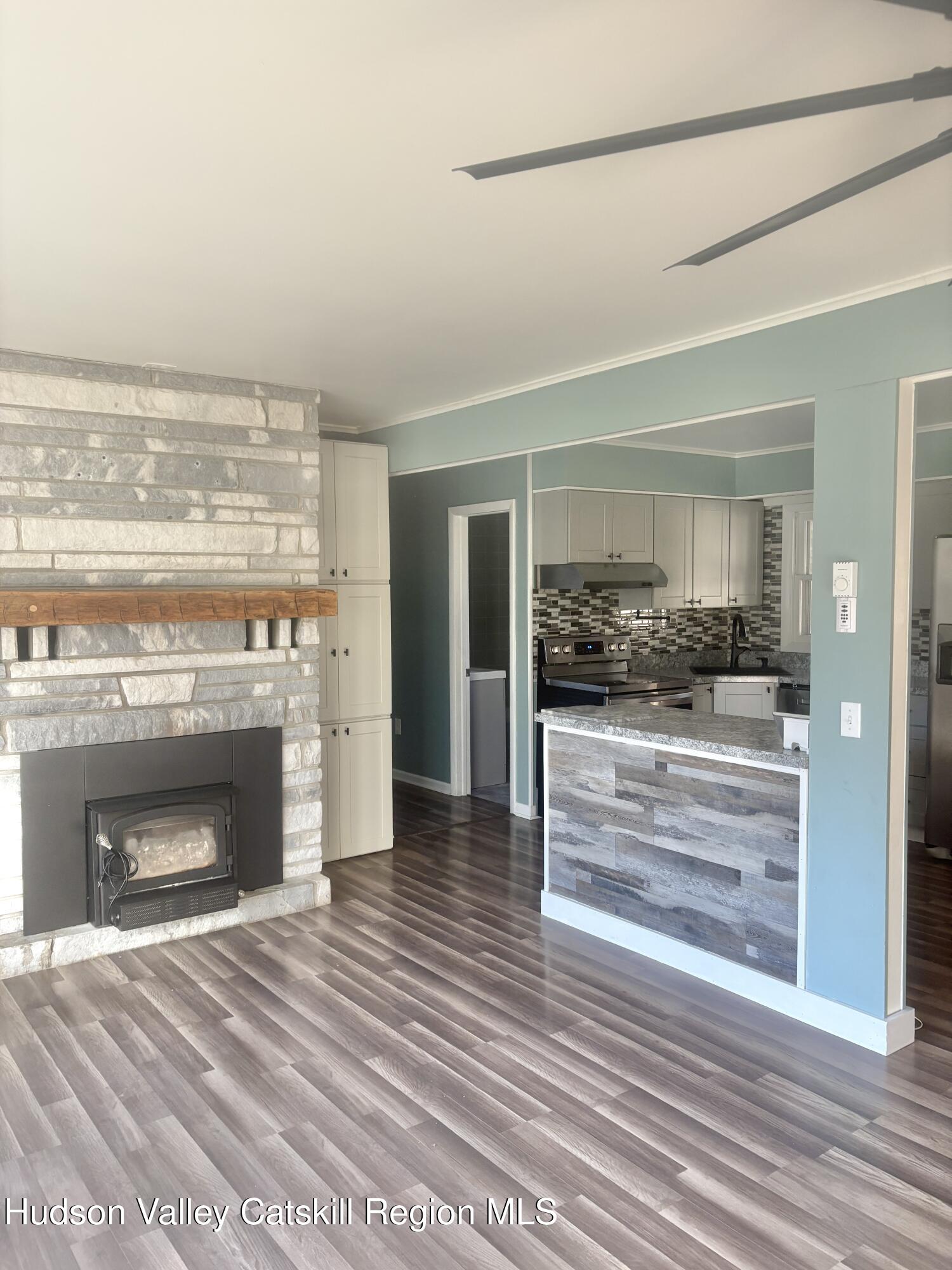 51 Hay Press Road Craryville, NY 12521 - Photo 5 of 27 a view of an empty room with a fireplace and wooden floor