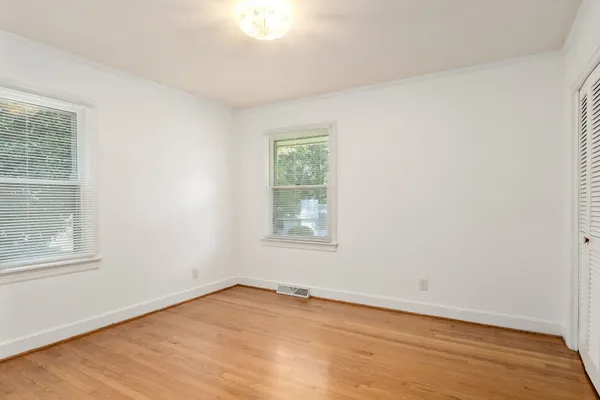 a view of an empty room with wooden floor