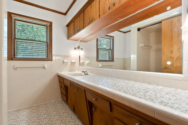 a bathroom with a granite countertop sink and a window