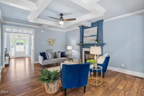 a living room with furniture a fireplace and a chandelier