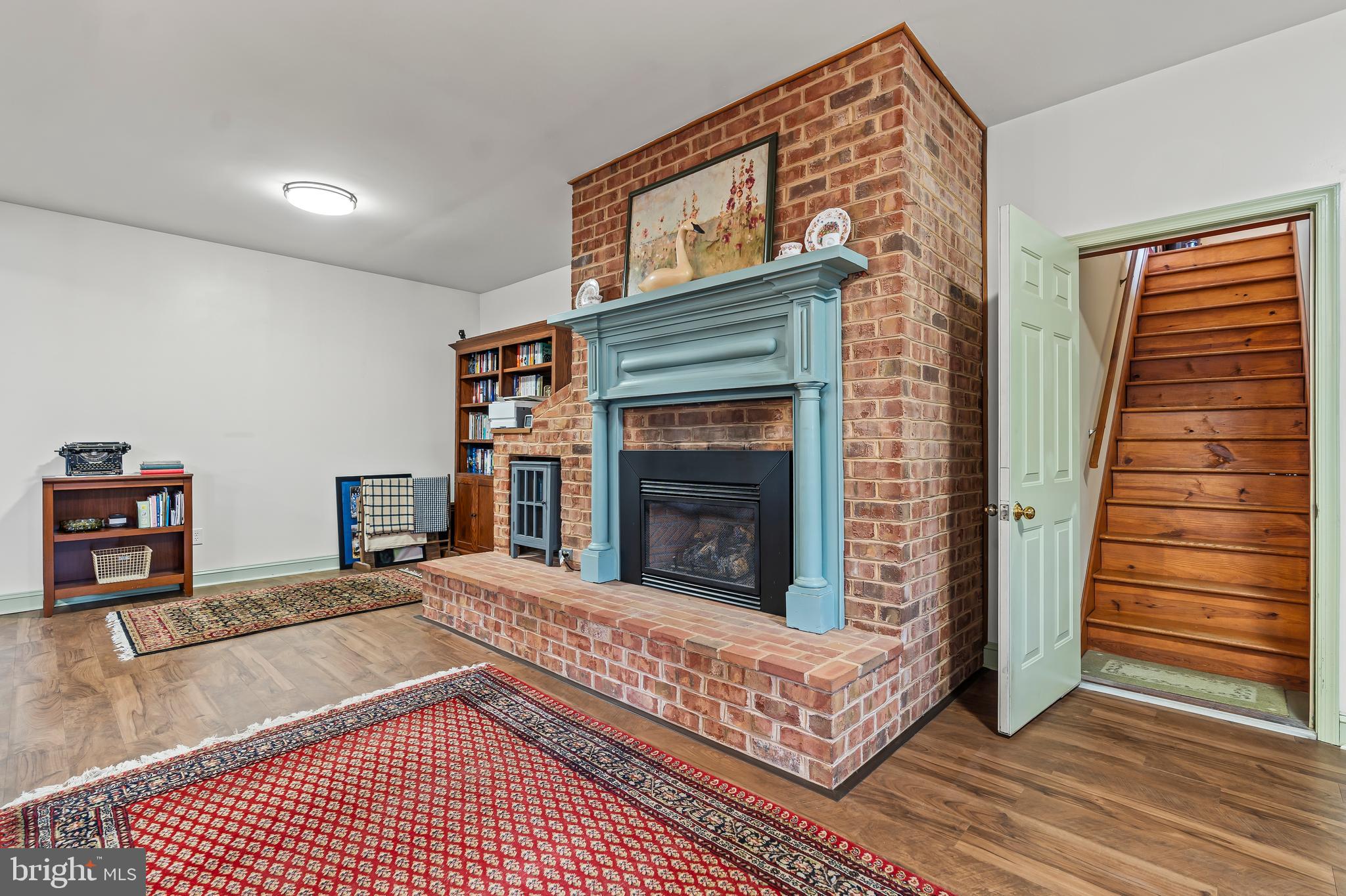 11625 Walnut Point Road Hagerstown, MD 21740 - Photo 60 of 118 a living room with furniture a fireplace and a wooden floor
