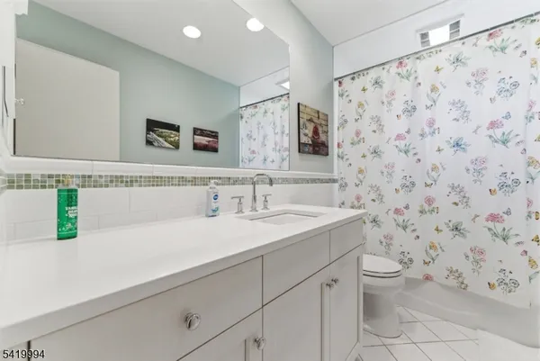 a bathroom with a granite countertop sink a toilet and a mirror