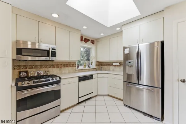 a kitchen with cabinets stainless steel appliances and sink