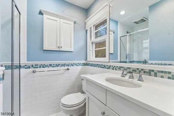 a bathroom with a sink toilet vanity and shower
