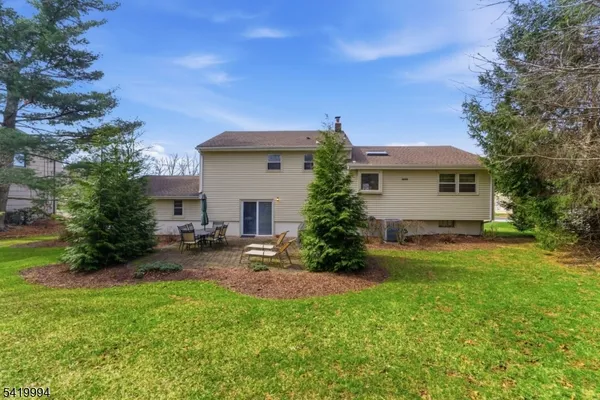 a view of a house with a backyard and a tree