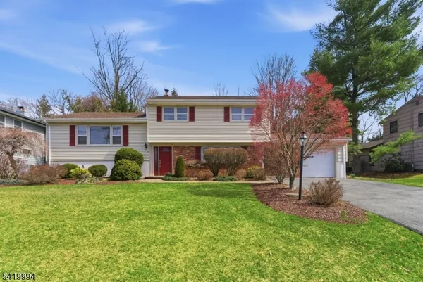 a view of a house with a yard and a tree