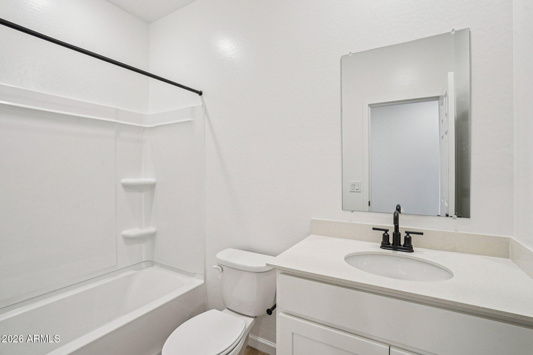 47638 West Moeller Road Maricopa, AZ 85139 - Photo 14 of 56 a bathroom with a sink toilet a mirror and shower