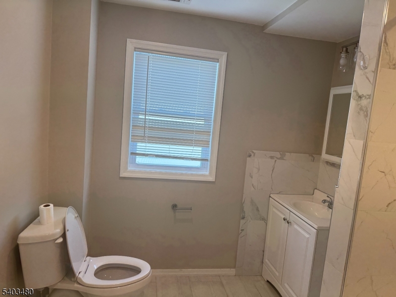 375 Tower Street Union, NJ 07088 - Photo 8 of 10 a white toilet sitting next to a bathroom sink and vanity