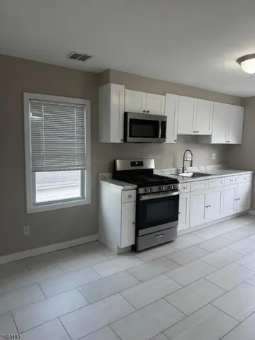 a kitchen with a stove a sink and a microwave