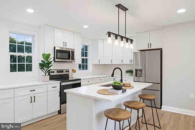 a kitchen with a refrigerator a stove a sink and chairs