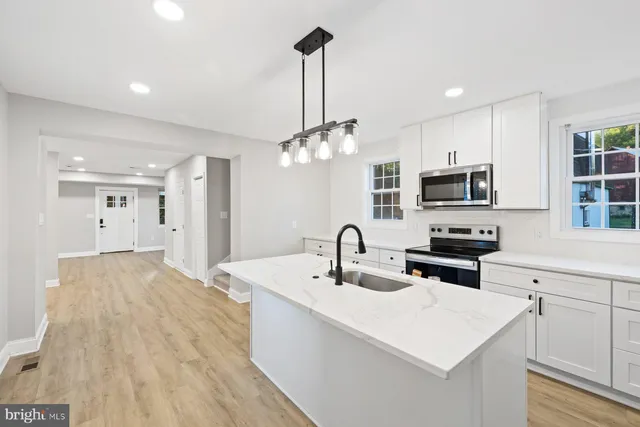 a kitchen with kitchen island a sink appliances and cabinets