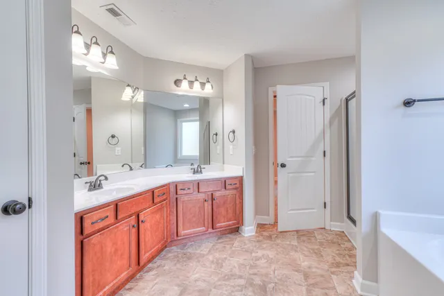 a spacious bathroom with a granite countertop sink mirror and bathtub
