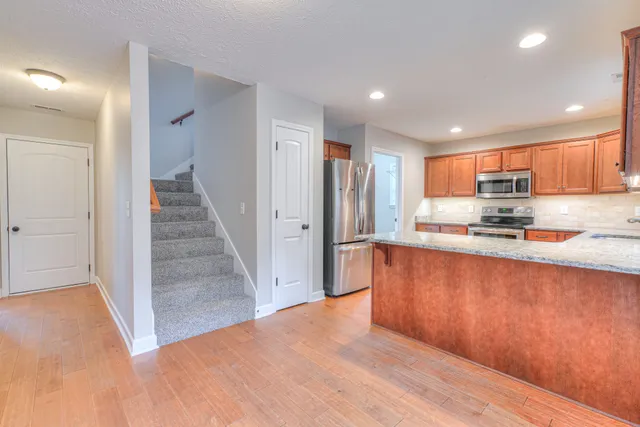 a kitchen with stainless steel appliances granite countertop a refrigerator and a sink