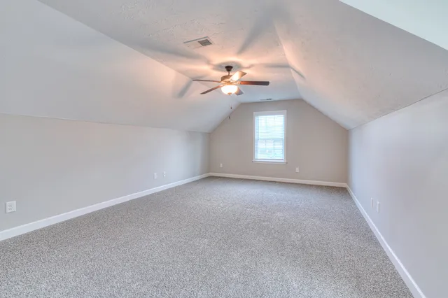 a view of a room with a ceiling fan and window