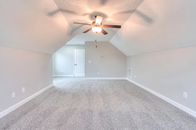 en empty room with ceiling fan and window