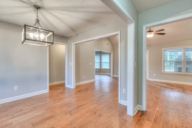 a view of a room with wooden floor staircase and a chandelier