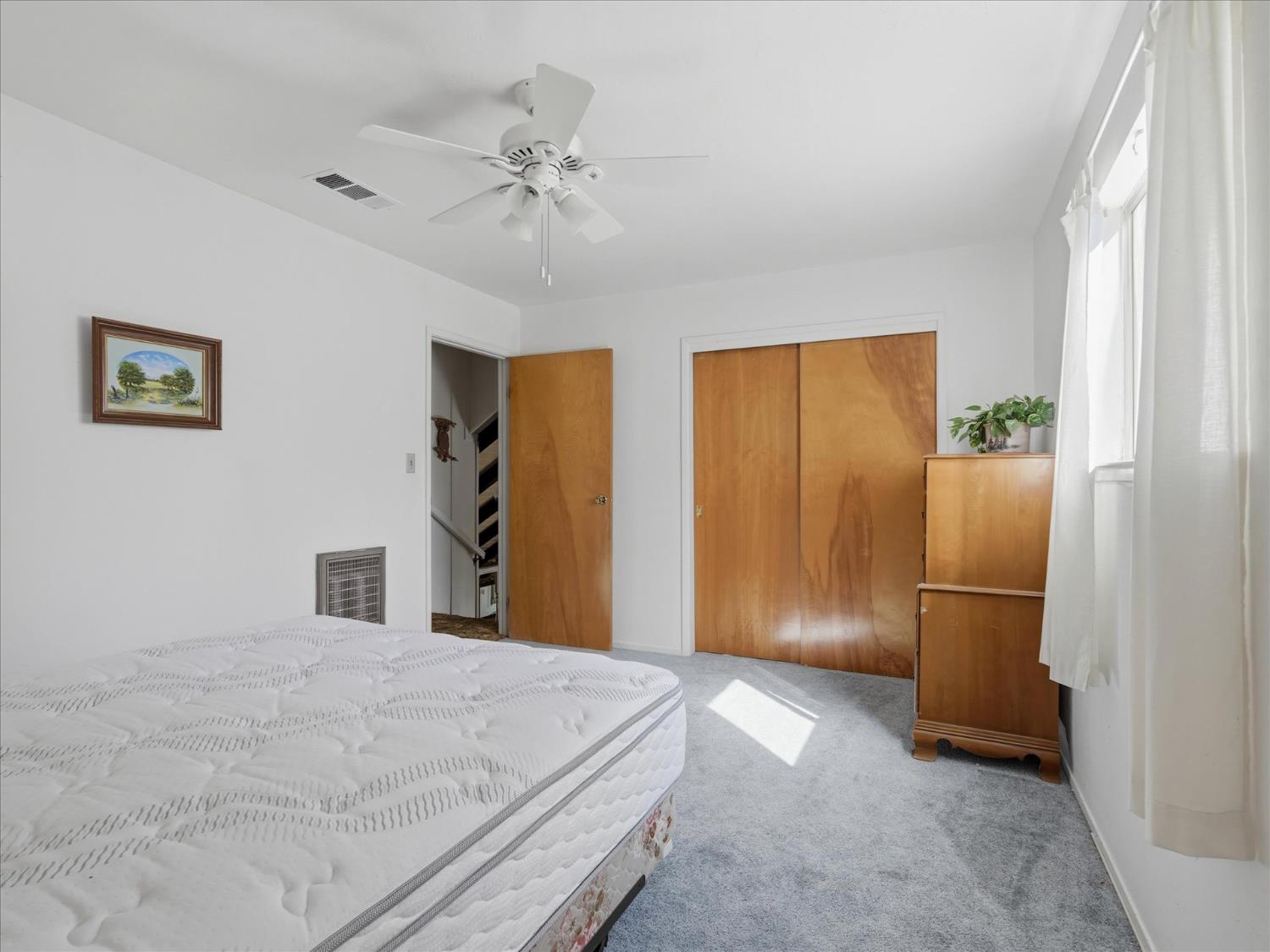 45167 Tolladay Road Oakhurst, CA 93644 - Photo 25 of 50 a bedroom with a bed and a chandelier