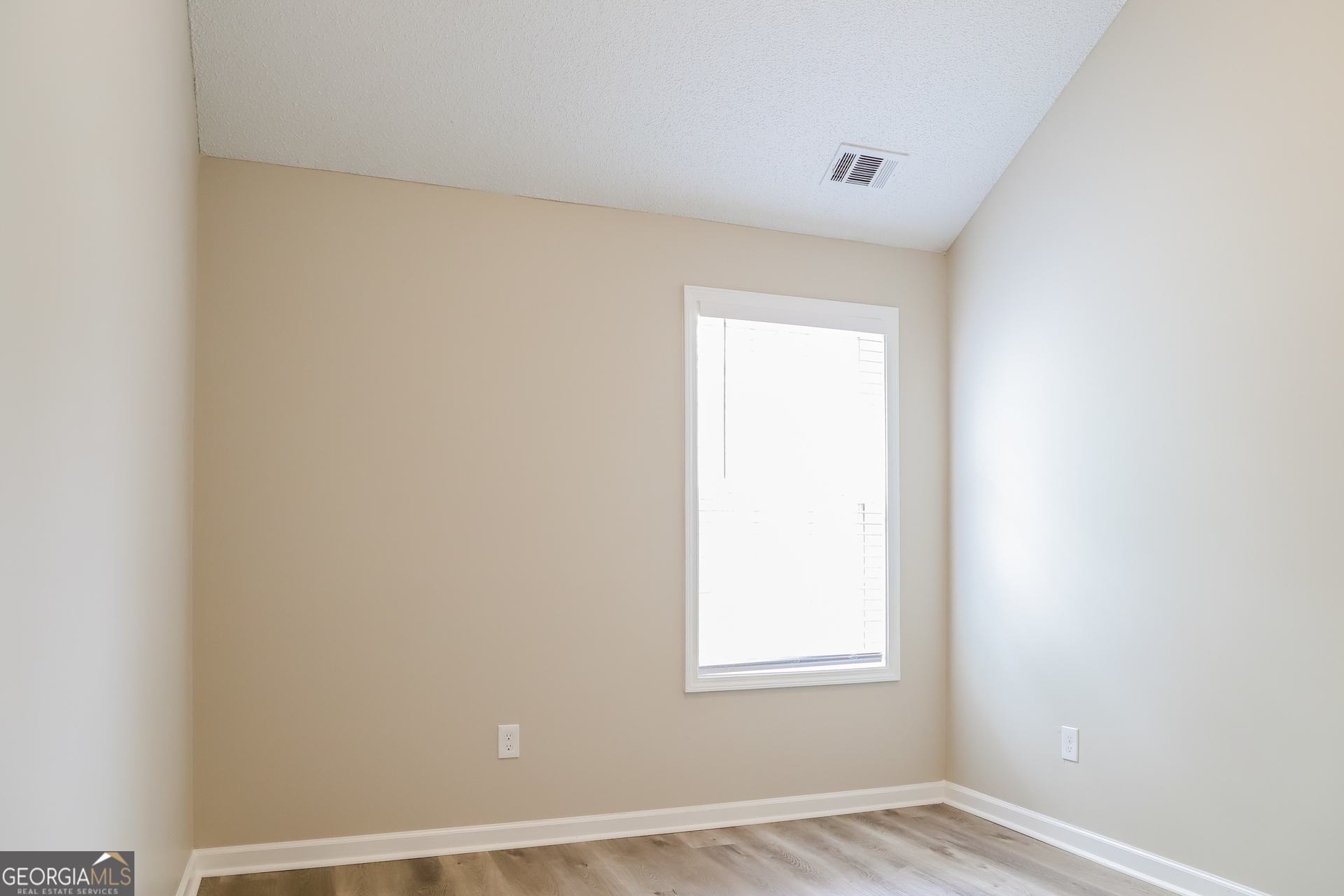 4976 Wolfcreek View South Fulton, GA 30349 - Photo 12 of 17 a view of an empty room with wooden floor and a window