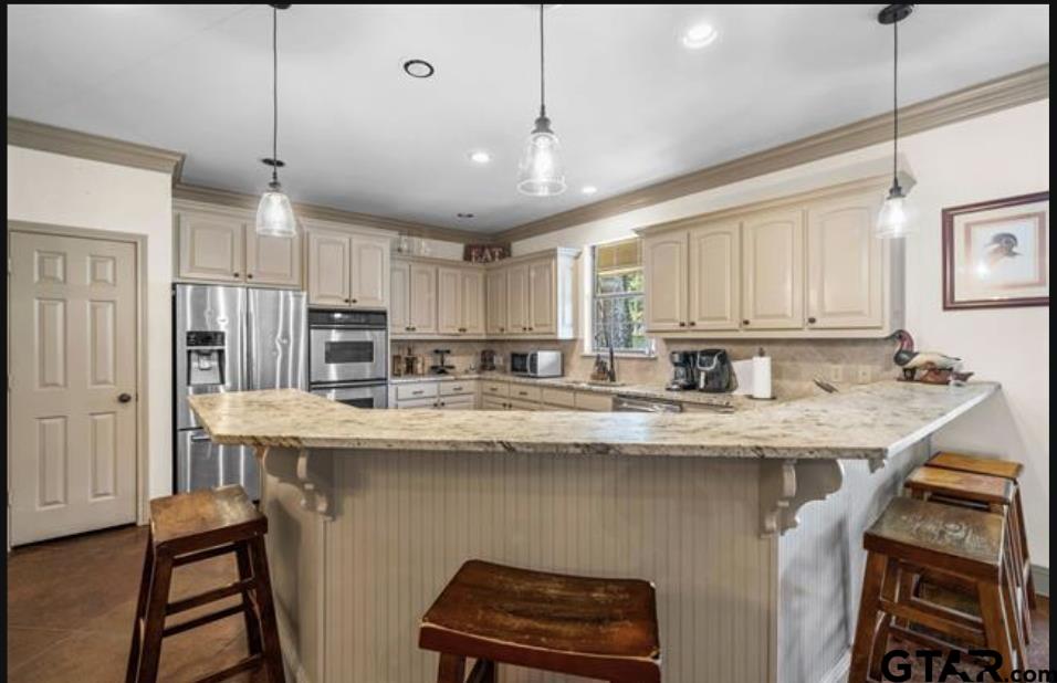 21192 Altuda Lane Flint, TX 75762 - Photo 10 of 46 a kitchen with stainless steel appliances granite countertop a sink a stove a refrigerator and island with wooden floor