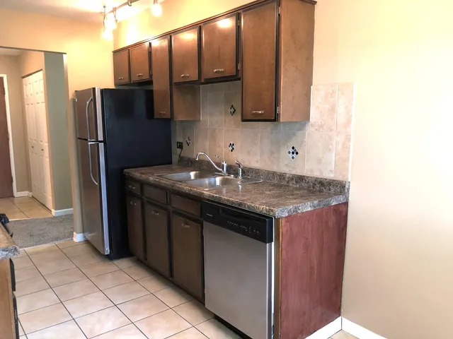 a kitchen with granite countertop wooden cabinets and stainless steel appliances