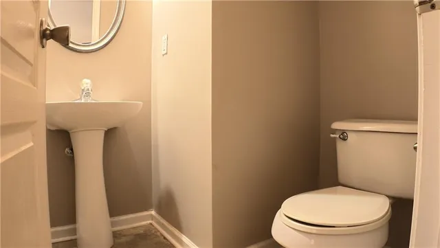 a white toilet sitting next to a shower