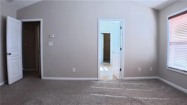 an empty room with windows and closet