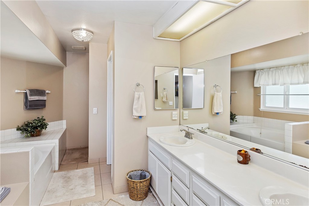 17411 Kaison Circle Riverside, CA 92508 - Photo 28 of 51 a spacious bathroom with a granite countertop sink and a mirror