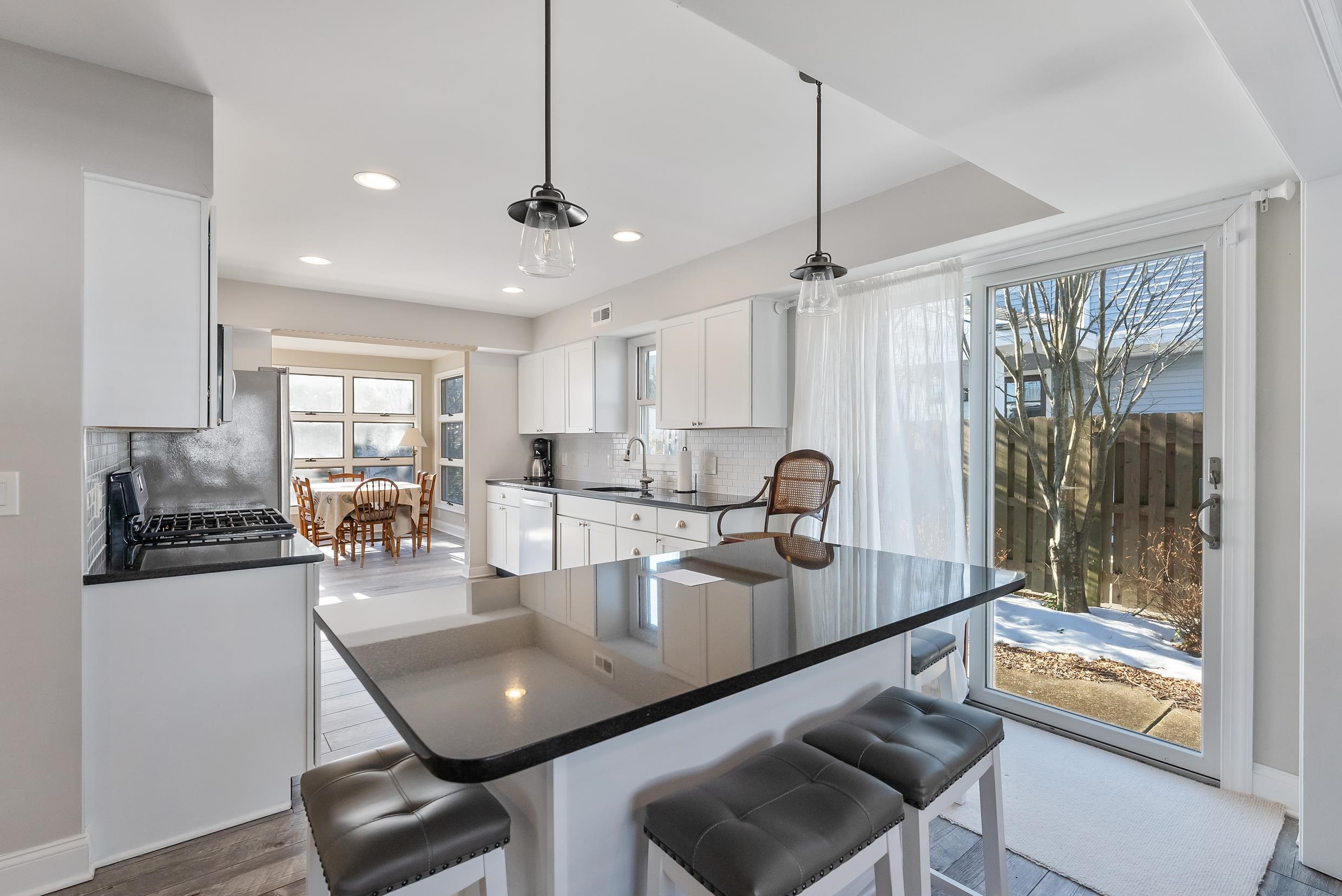 274 52nd Street Avalon, NJ 08202 - Photo 20 of 39 a kitchen with a dining table chairs sink and glass door