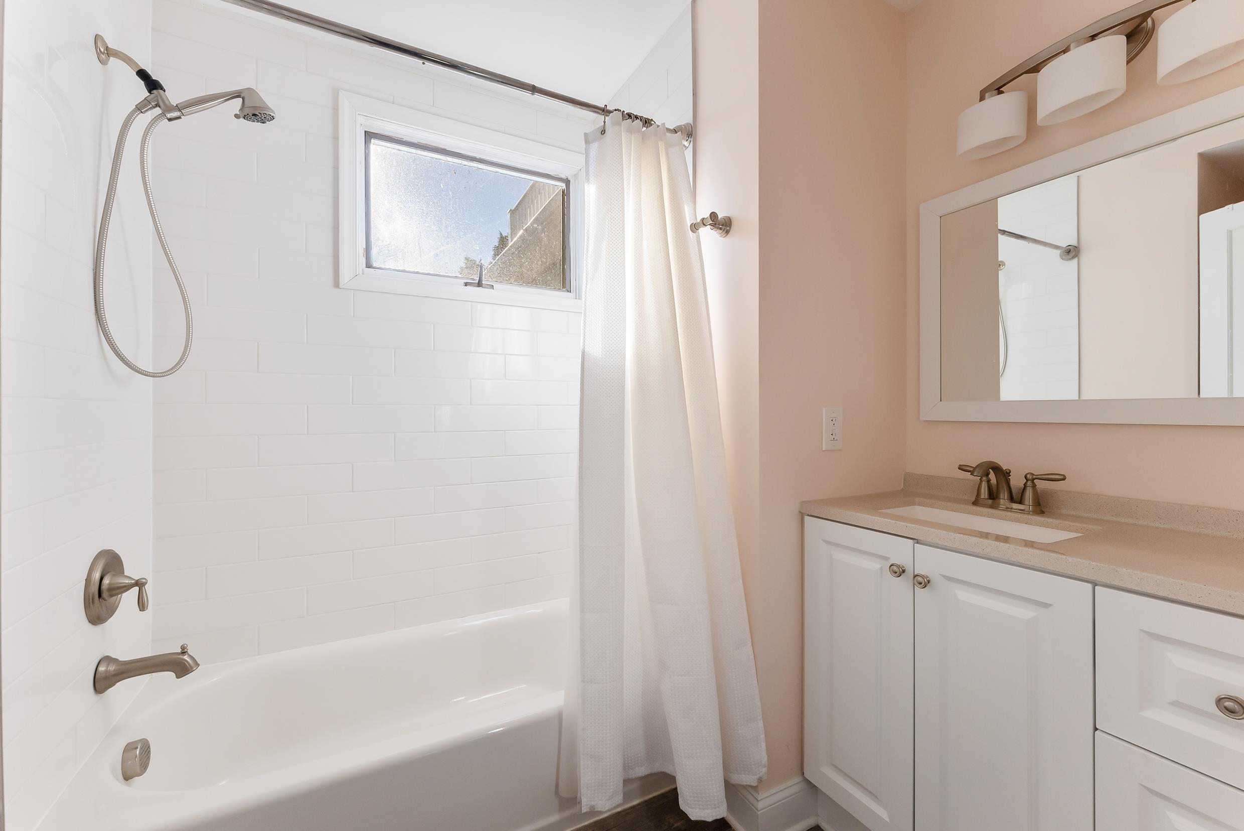 274 52nd Street Avalon, NJ 08202 - Photo 30 of 39 a bathroom with a granite countertop sink two mirror and a bathtub