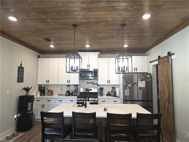 a kitchen with refrigerator and chairs