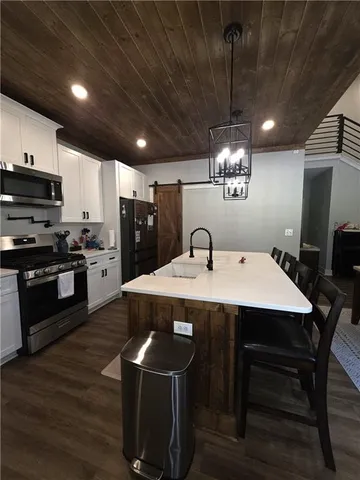 a kitchen with a table chairs refrigerator and microwave