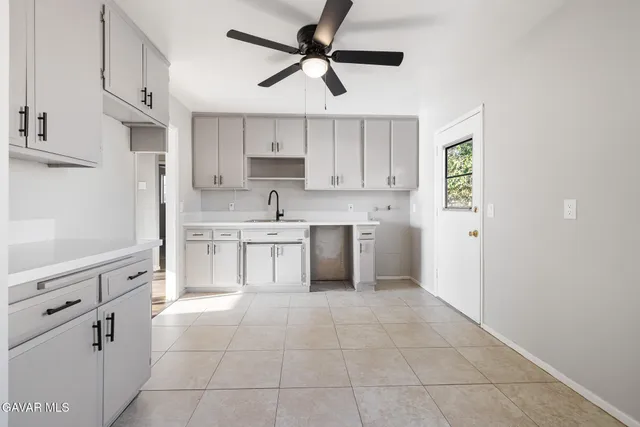 a kitchen with white cabinets appliances and a sink
