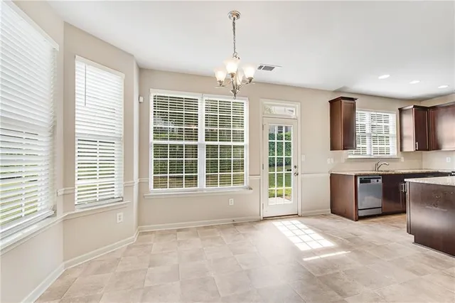 a view of an empty room with kitchen window and wooden floor