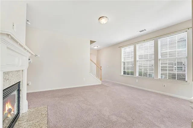 a view of an empty room with a fireplace and a window