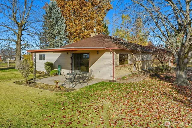 a view of a house with backyard and sitting area