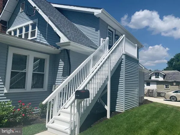 a view of house with yard and deck
