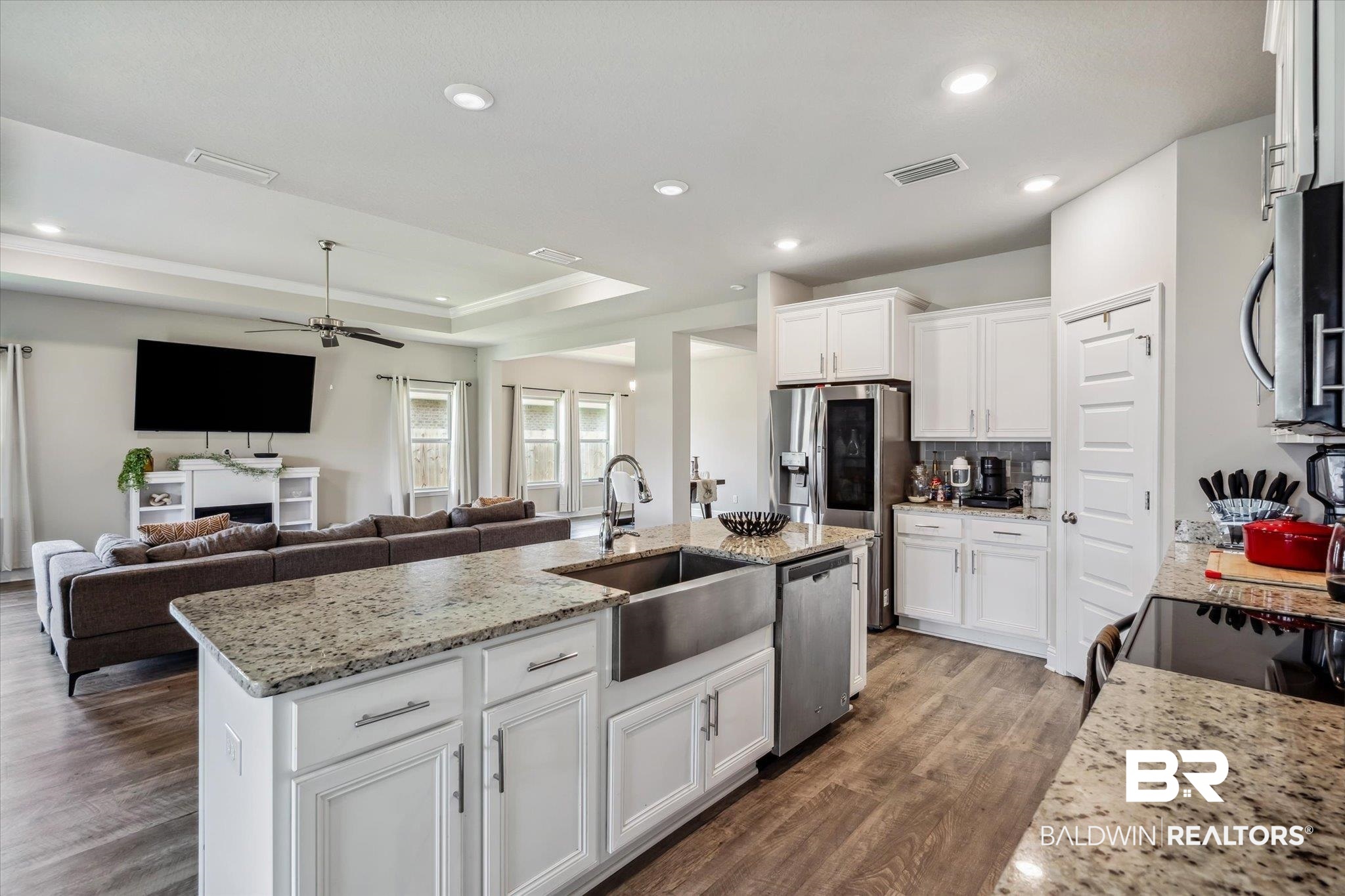 10501 Loamy Avenue Mobile, AL 36695 - Photo 8 of 30 Kitchen featuring white cabinetry, hardwood / wood-style flooring, a raised ceiling, and appliances with stainless steel finishes
