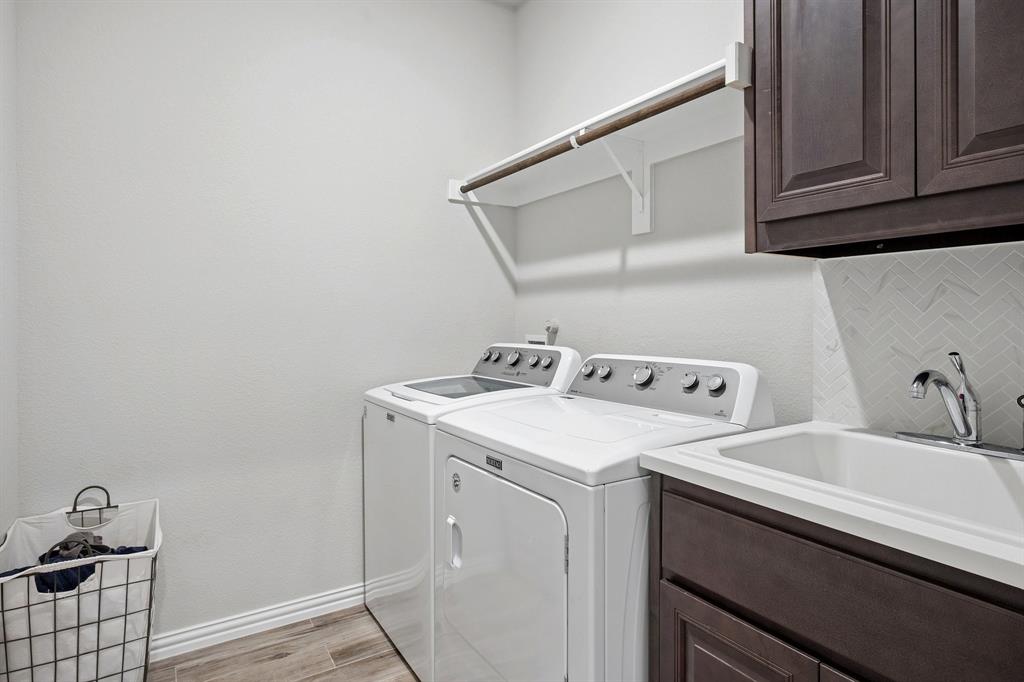 15057 Ted Trail Aledo, TX 76008 - Photo 28 of 35 Spacious laundry with cabinets, hanging rack and a sink!