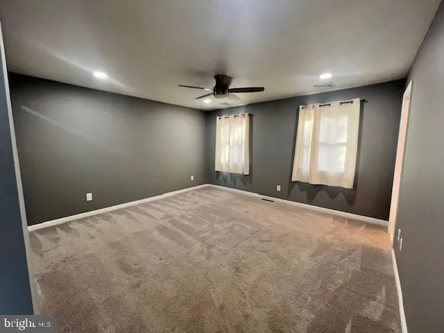 a view of a livingroom with a ceiling fan and window