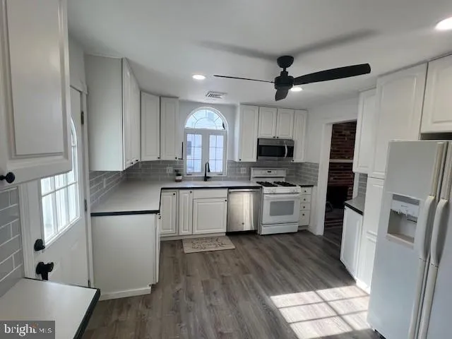 a kitchen with a refrigerator a stove top oven a sink and dishwasher
