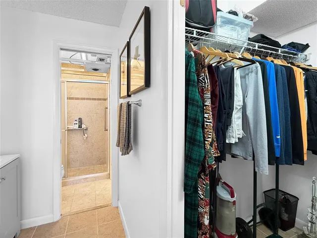 a view of walk in closet with clothes and shoes