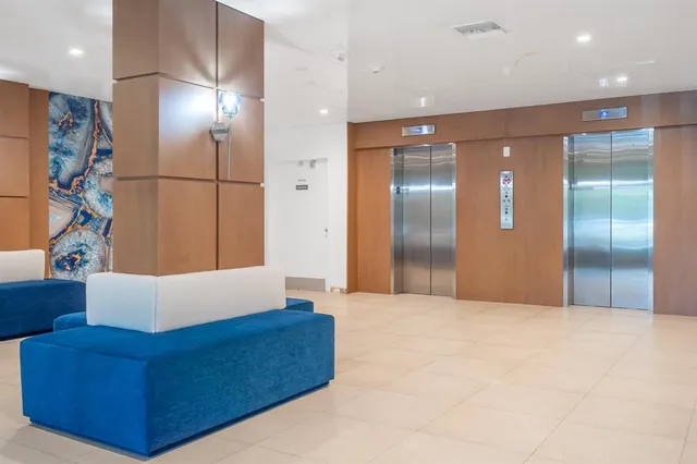 a living room with stainless steel appliances kitchen island granite countertop a refrigerator and a sink